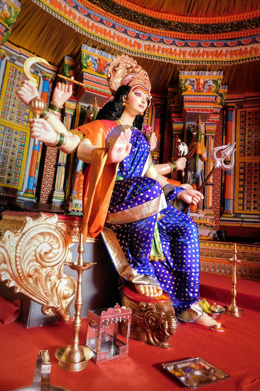 woman in blue and gold sari dress sitting on gold chair
