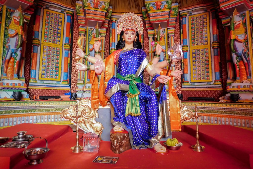 woman in purple and gold sari sitting on chair