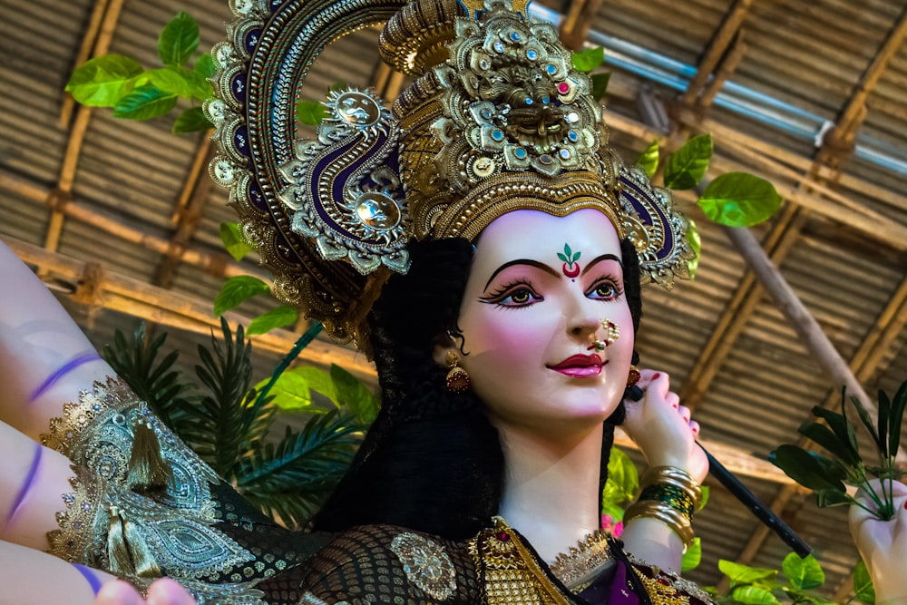 woman in gold and green floral dress wearing gold crown