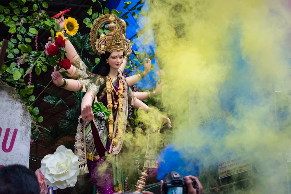 Frau in goldenem und weißem Blumenkleid mit goldener Krone