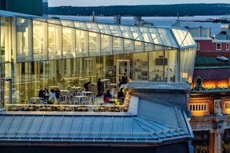 people sitting on bench near glass building during daytime