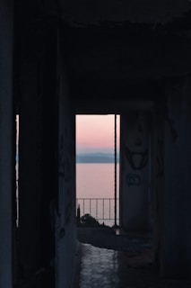 An abandoned onsen at dusk, its cracked tiles glistening under a bloody red sky.