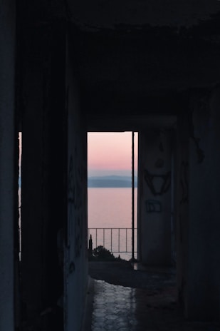 An abandoned onsen at dusk, its cracked tiles glistening under a bloody red sky.