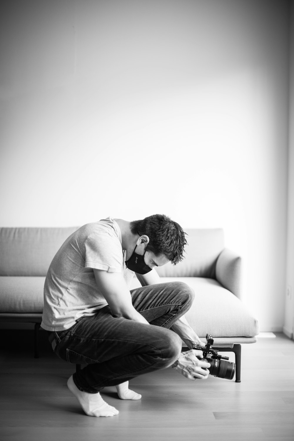 man in white t-shirt and black denim jeans sitting on couch