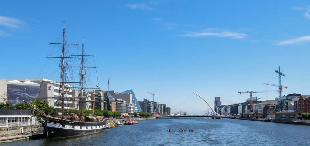 people riding on boat on river near buildings during daytime