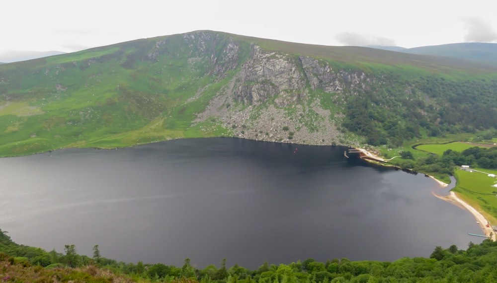 green and gray mountain beside body of water during daytime