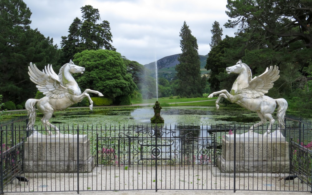 white statue of man riding horse near green trees during daytime