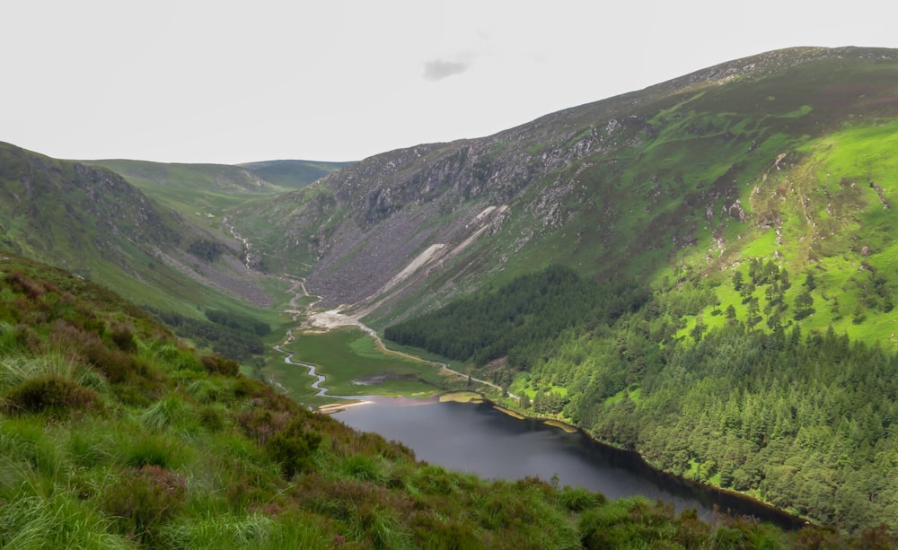 green mountains beside river during daytime