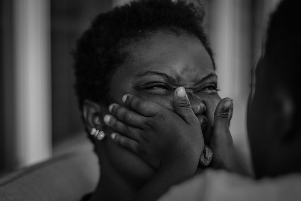 grayscale photo of man covering his face