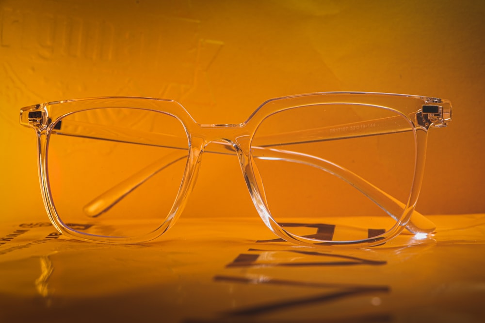 silver framed eyeglasses on brown wooden table