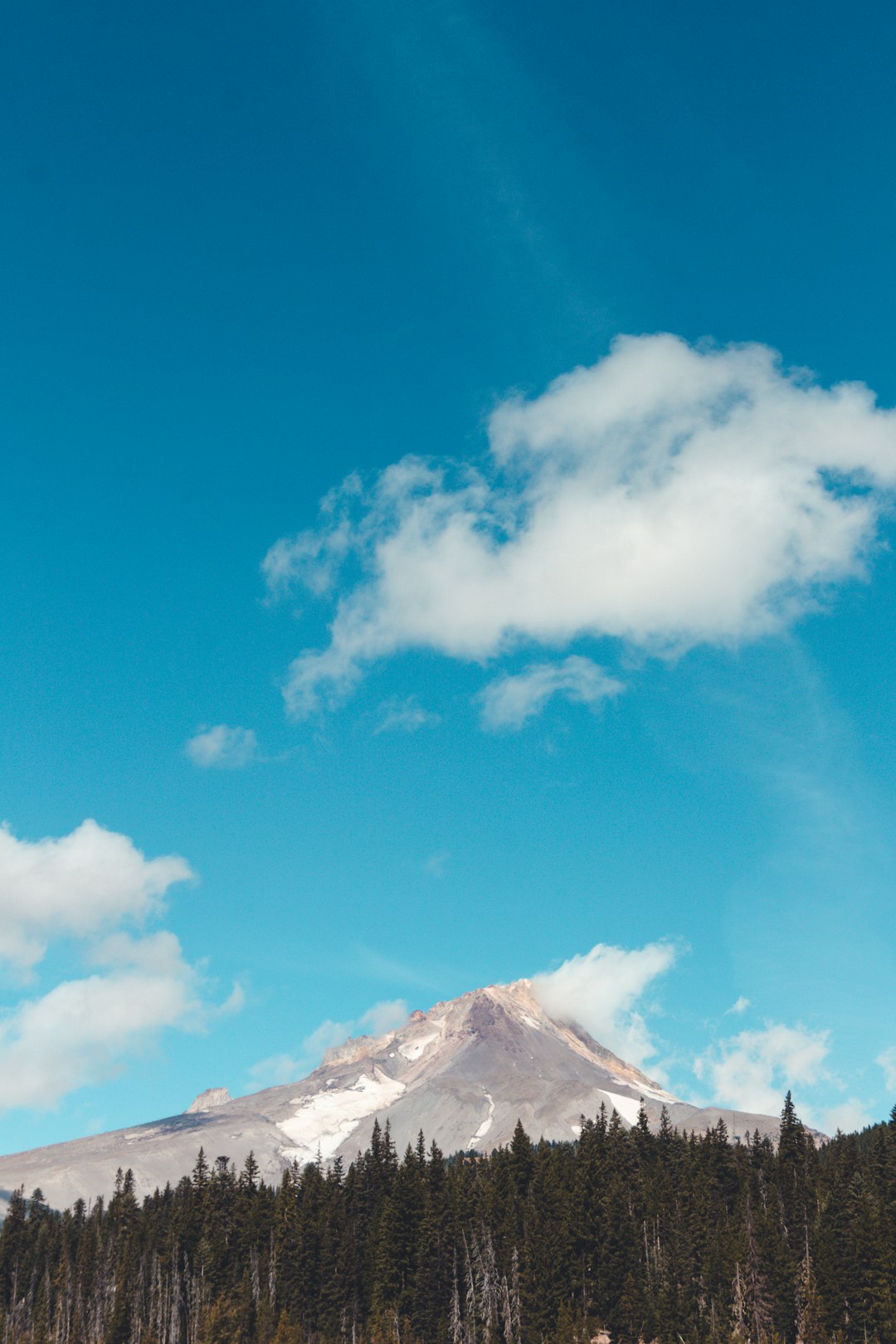 white clouds over snow covered mountain