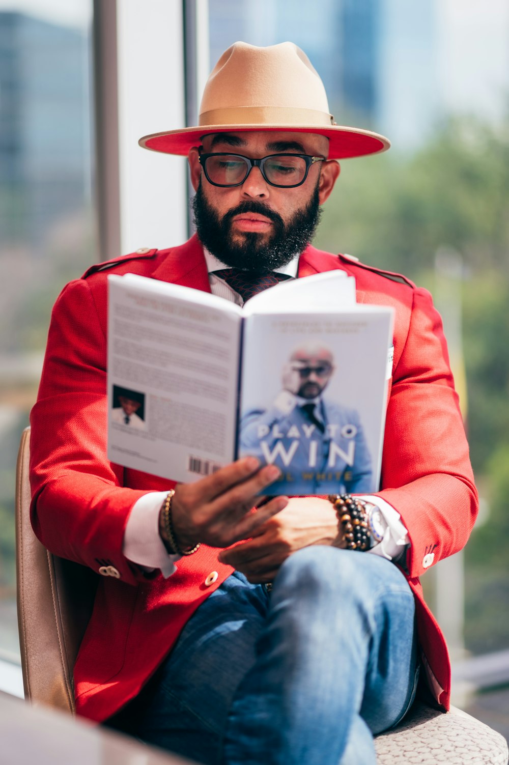 man in red long sleeve shirt holding white book