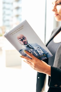 person holding white and blue book