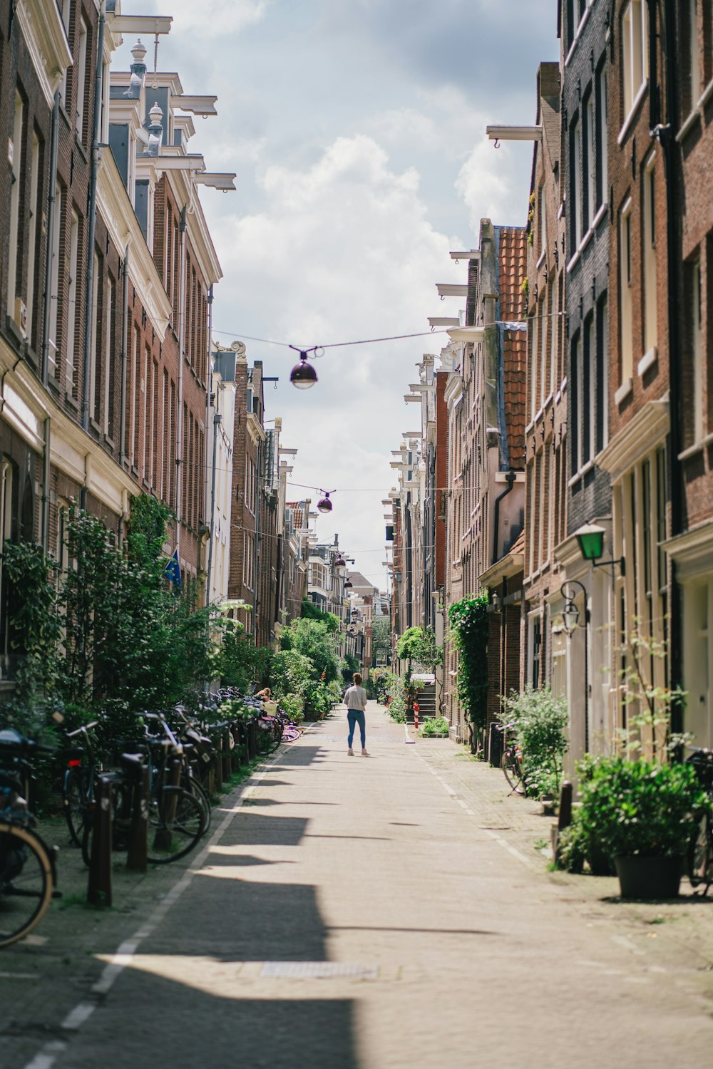 people walking on sidewalk between buildings during daytime