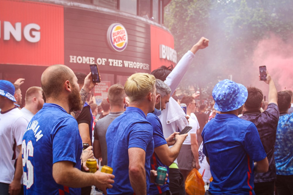 people in blue shirts standing and holding yellow and white powder