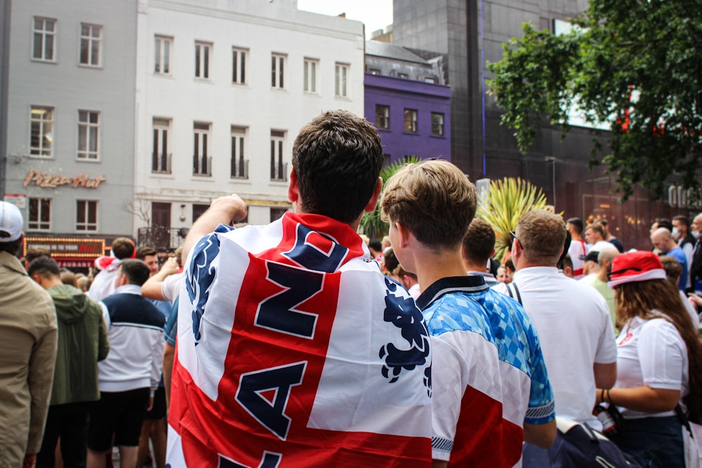 people in blue and red shirt standing on street during daytime