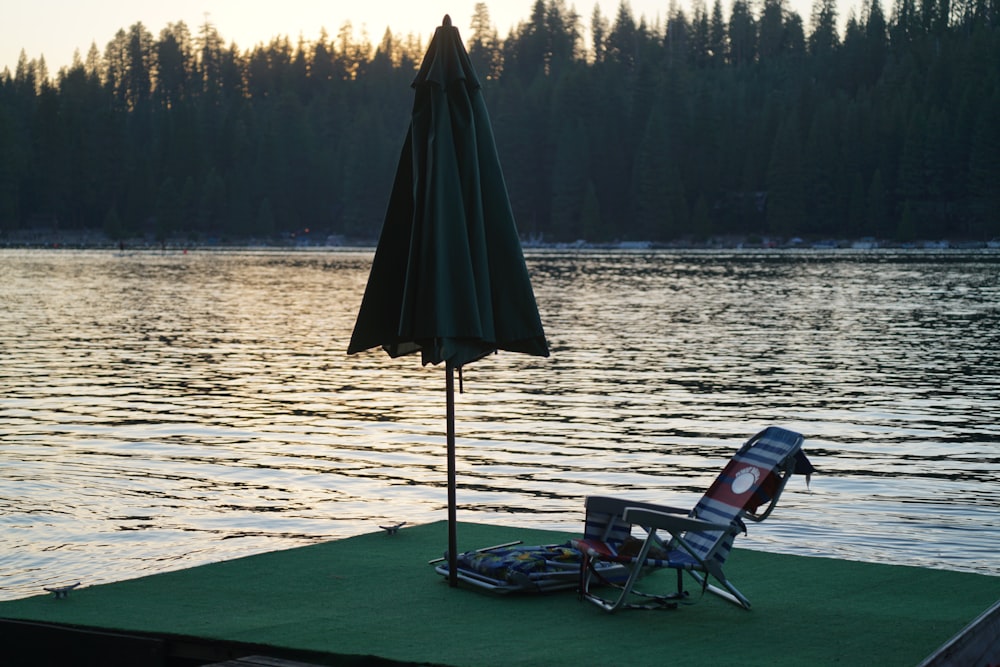 black and green camping chair near body of water during daytime