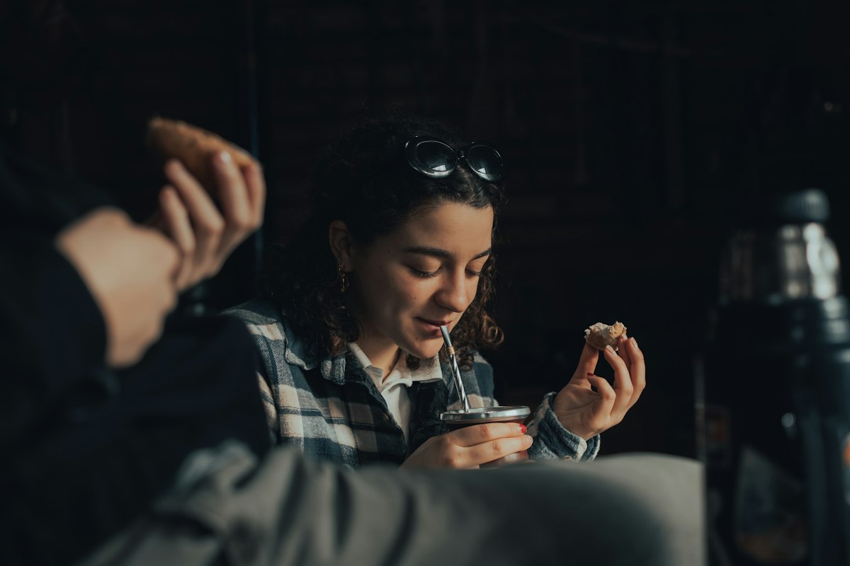 Woman in black and white plaid shirt holding a silver spoon