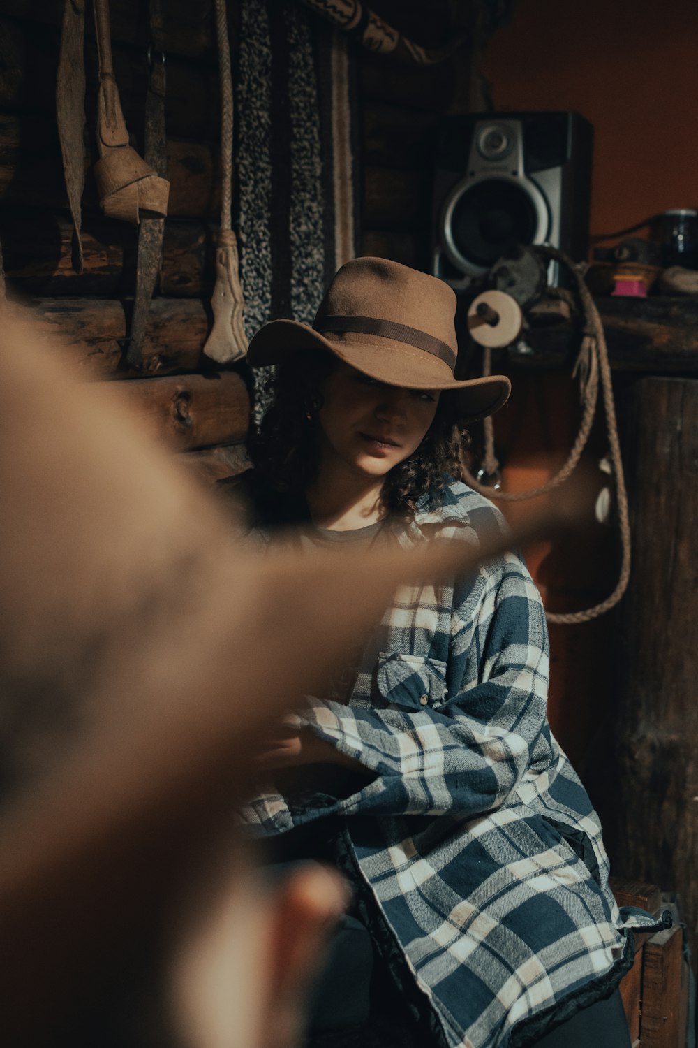 woman in white and black plaid shirt wearing brown hat