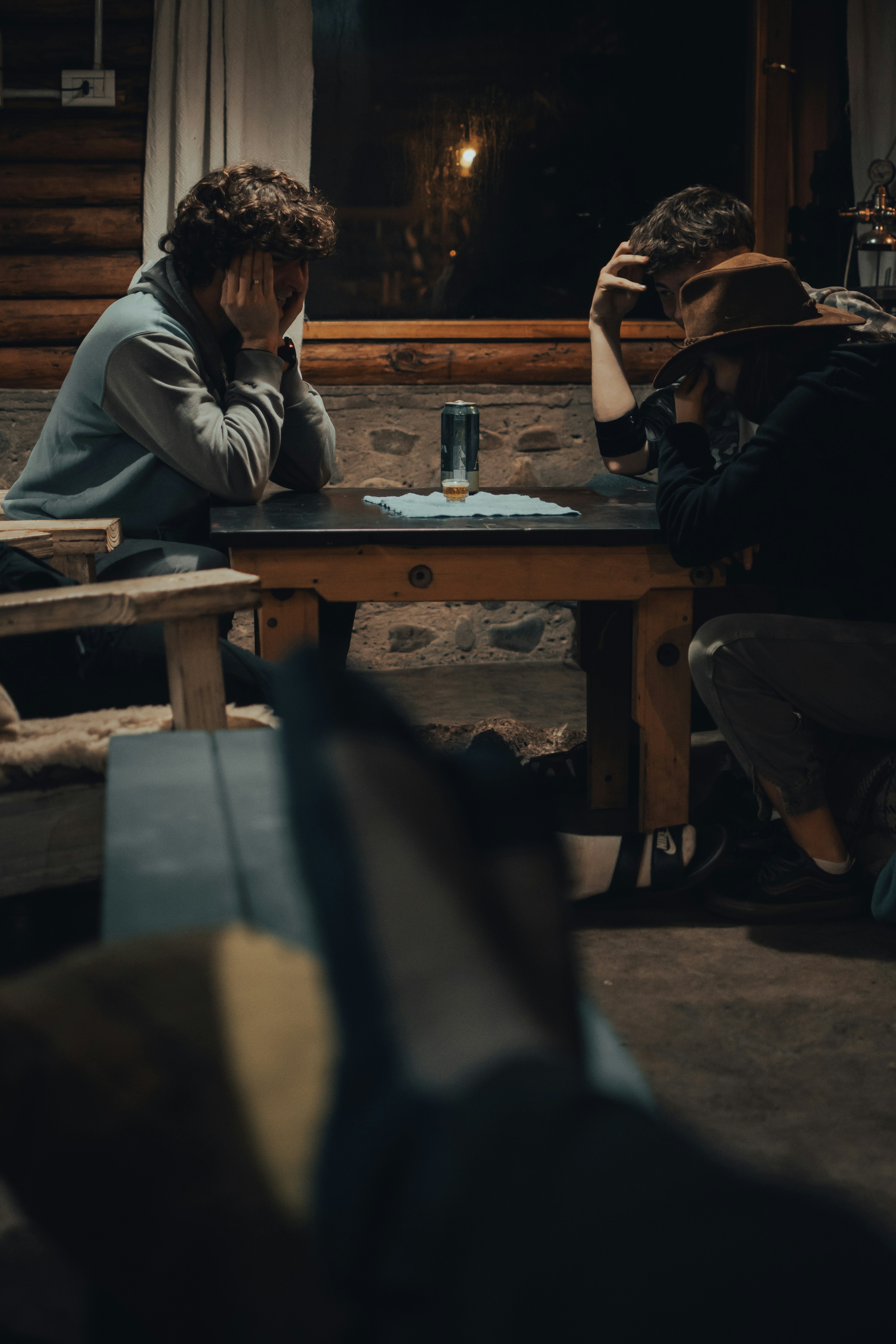 man in white hoodie sitting on brown wooden chair