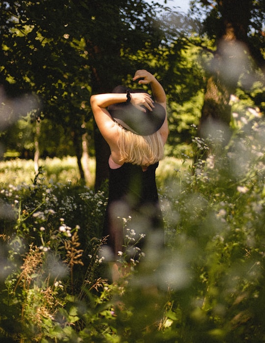 woman in brown dress standing on green grass field in Csöde Hungary