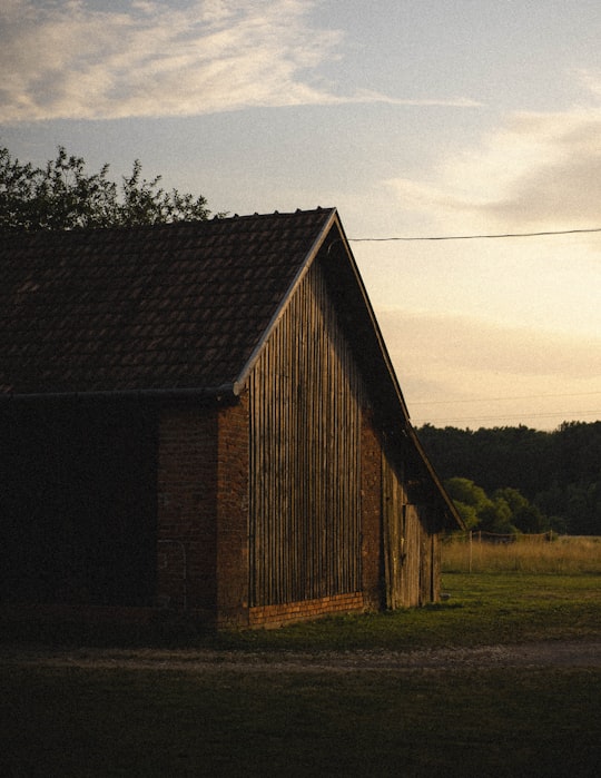 brown wooden house near green trees during daytime in Csöde Hungary