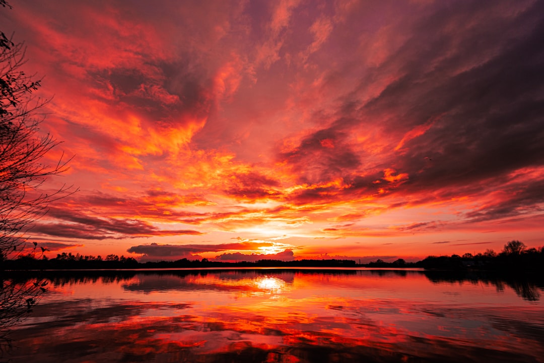 body of water under cloudy sky during sunset