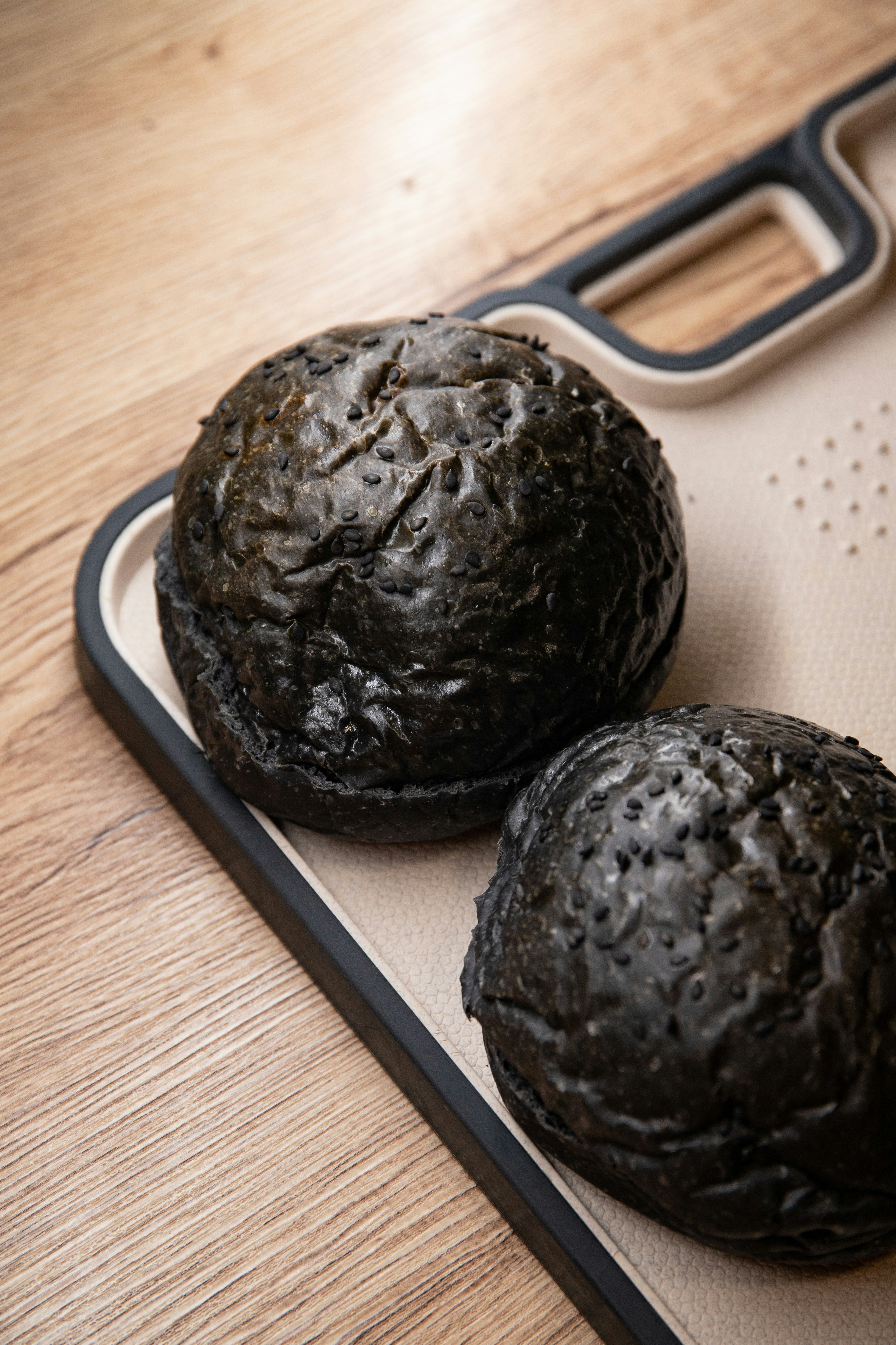 2 black round fruits on white table mat