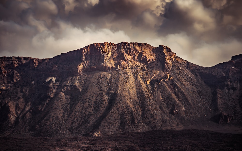 brown rocky mountain under cloudy sky during daytime