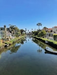 white and brown concrete building beside river under blue sky during daytime