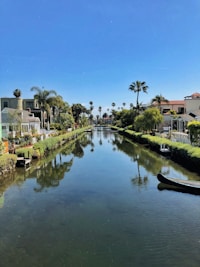 white and brown concrete building beside river under blue sky during daytime