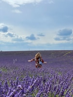 woman in black and brown dress standing on purple flower field during daytime