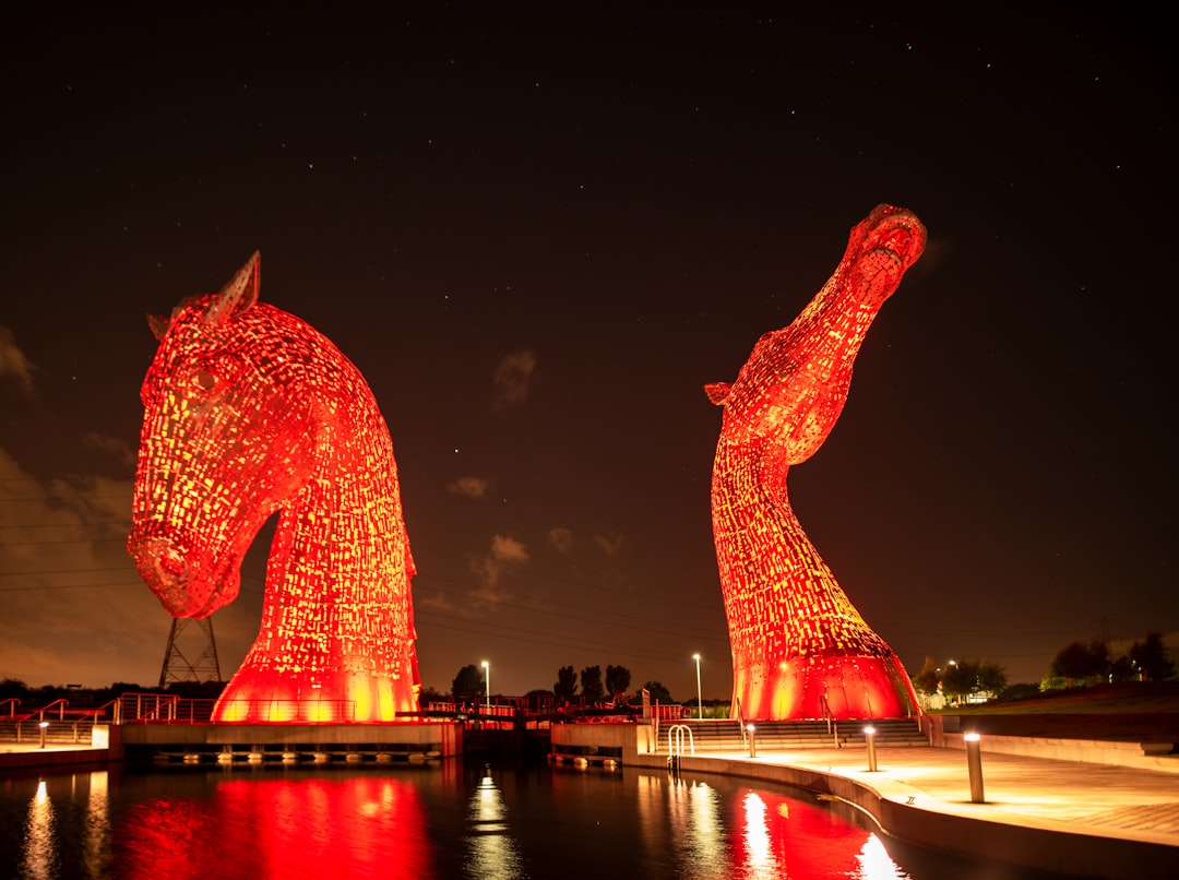 red dragon statue near body of water during night time