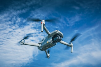 white and black drone flying under blue sky during daytime