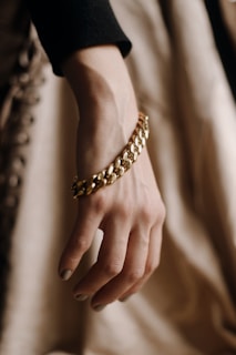 Close-up of a gold chain bracelet on a male wrist.