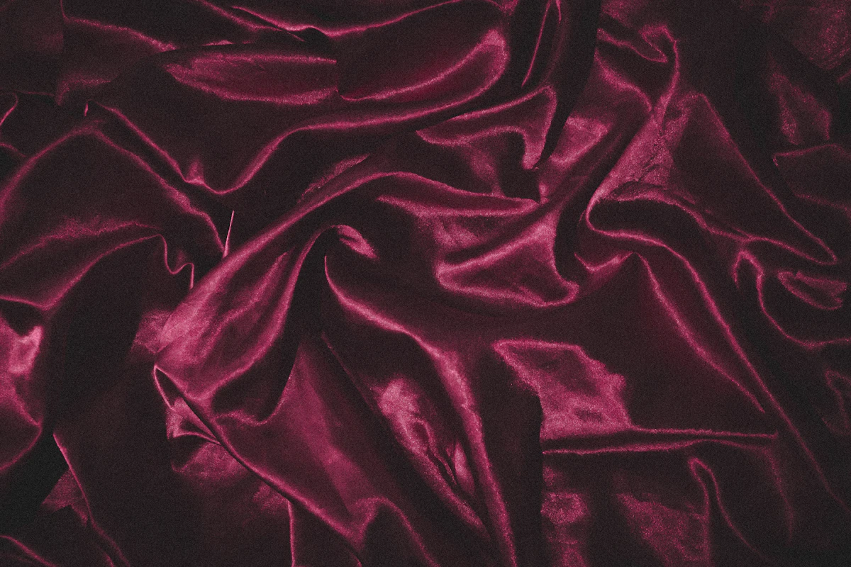 Velours rouge profond, plis souples