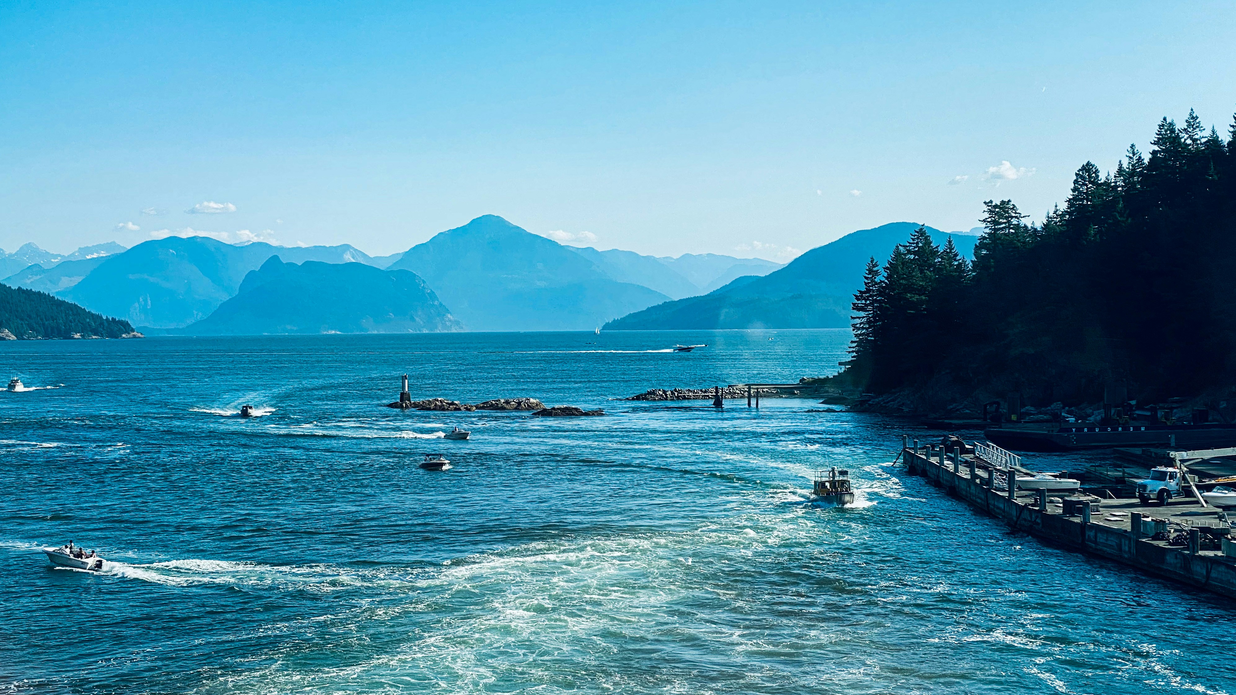 people on boat on sea near mountain during daytime