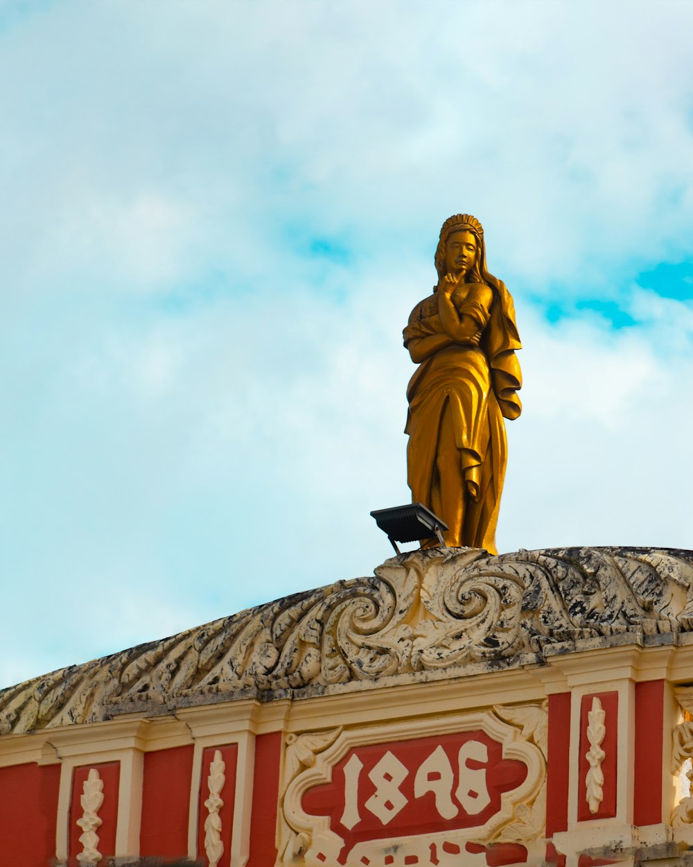 gold statue of man on top of a building