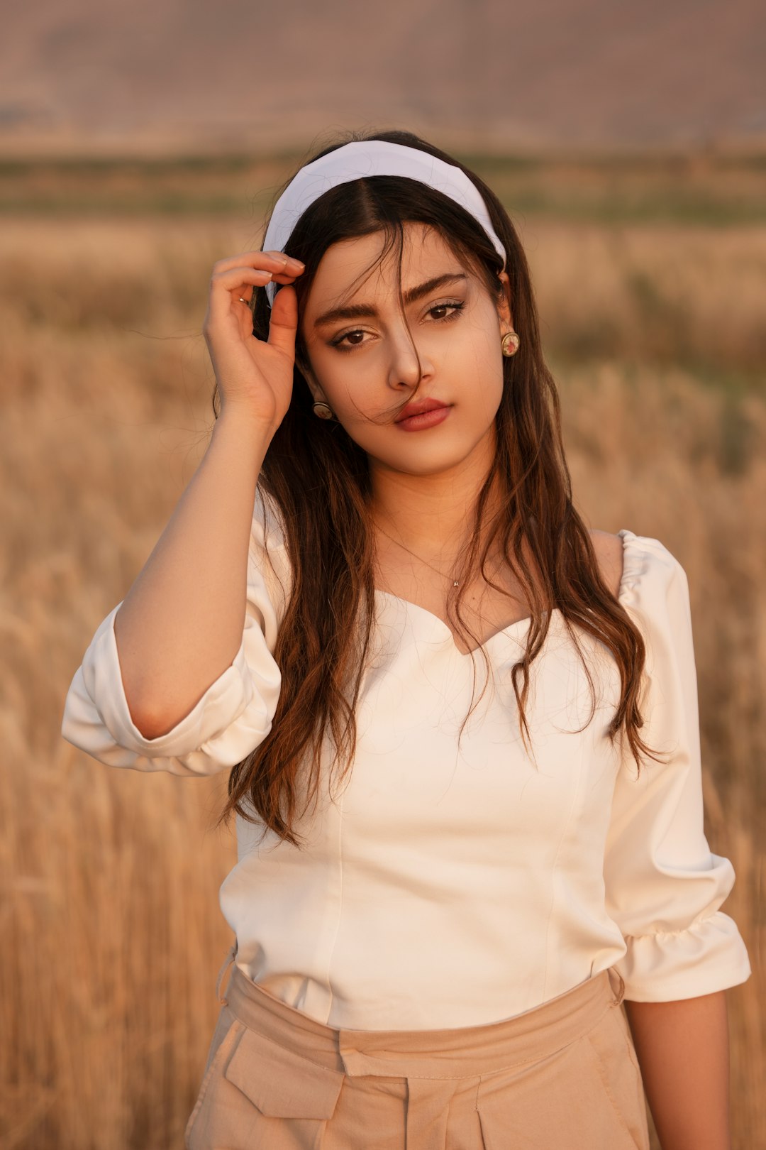 woman in white long sleeve shirt holding red smartphone