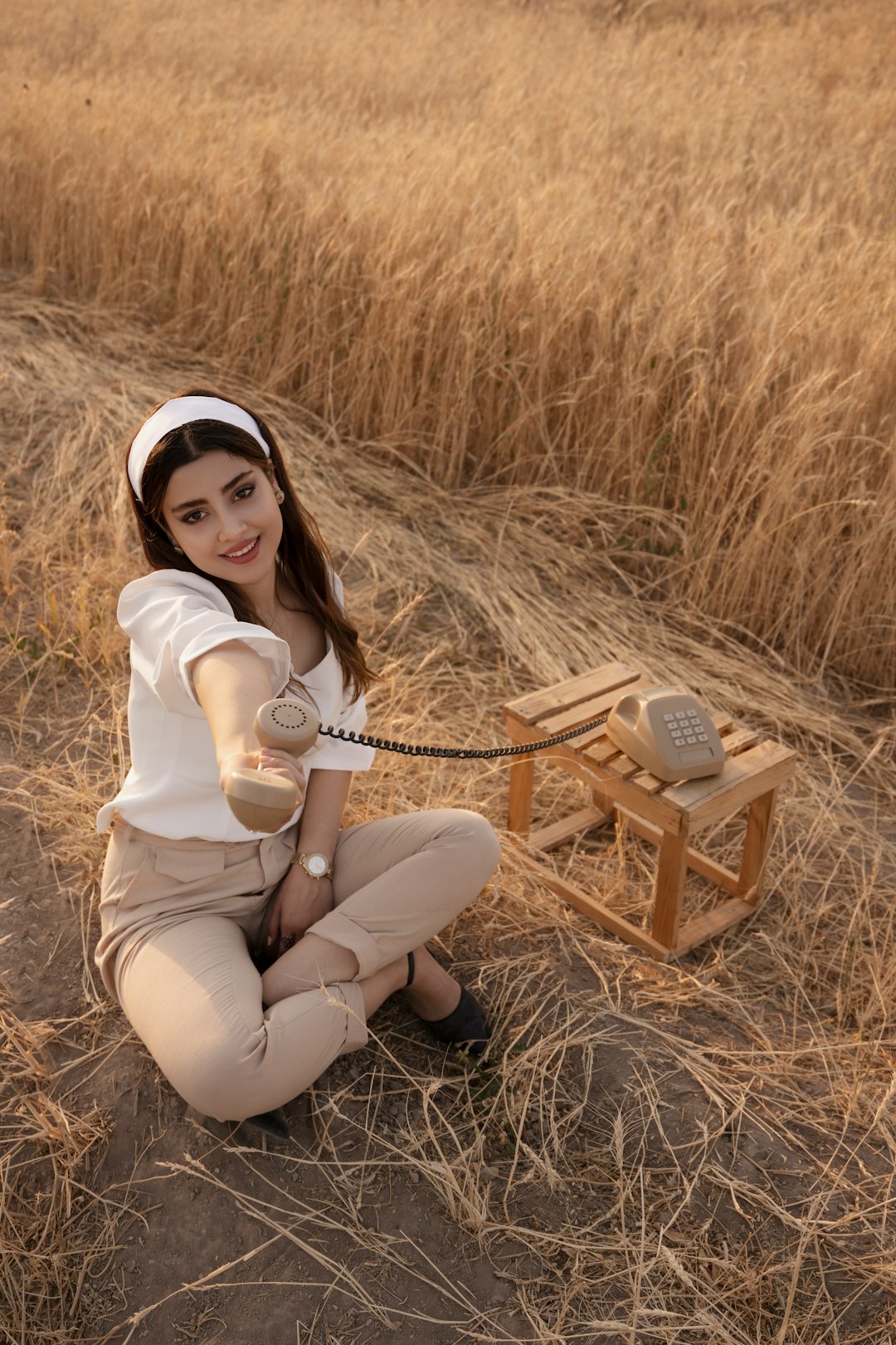 woman in white long sleeve shirt and blue denim shorts sitting on brown wooden seat