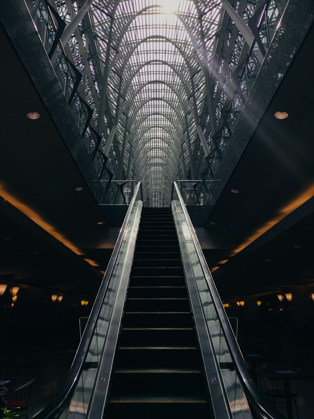 gray and black escalator in a tunnel