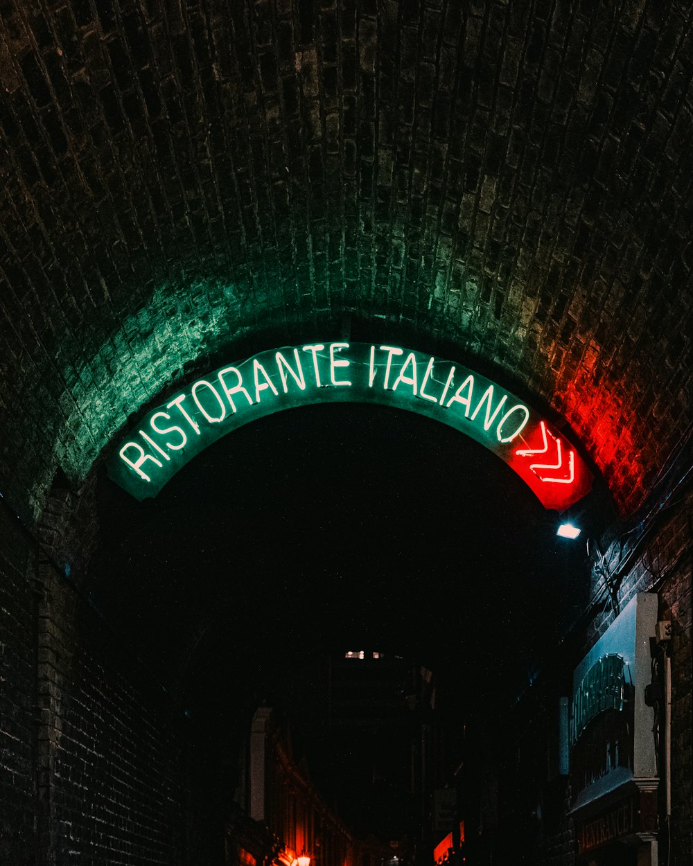 a dark tunnel with a neon sign above it