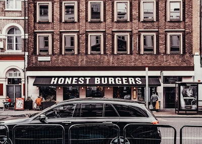 black sedan parked beside store honest zoom background