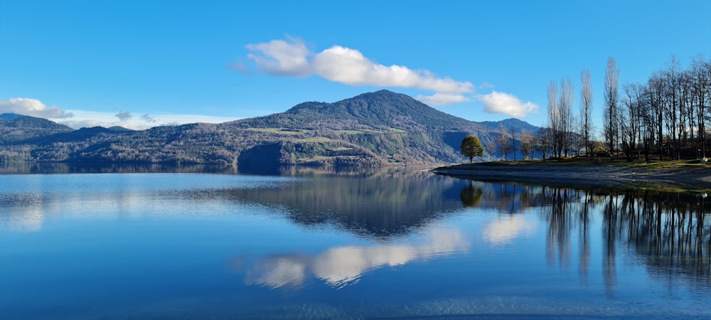 lake near mountain under blue sky during daytime