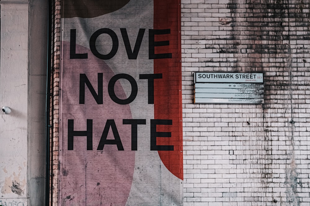 Ein Schild an einer Ziegelmauer, das Liebe statt Hass sagt