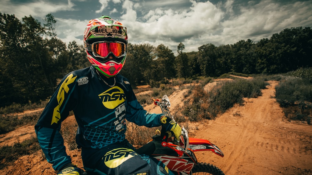 man in black and yellow jacket riding motocross dirt bike