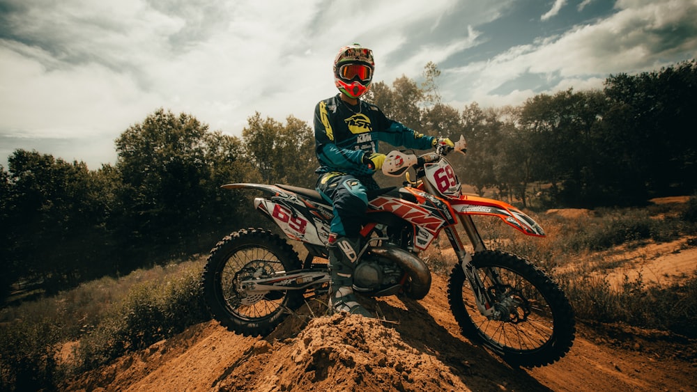 homme en costume de moto bleu et rouge conduisant une moto tout-terrain de motocross