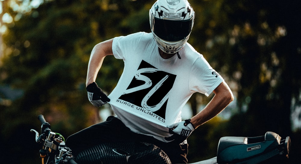 man in white and black nike t-shirt and black pants wearing black and white helmet