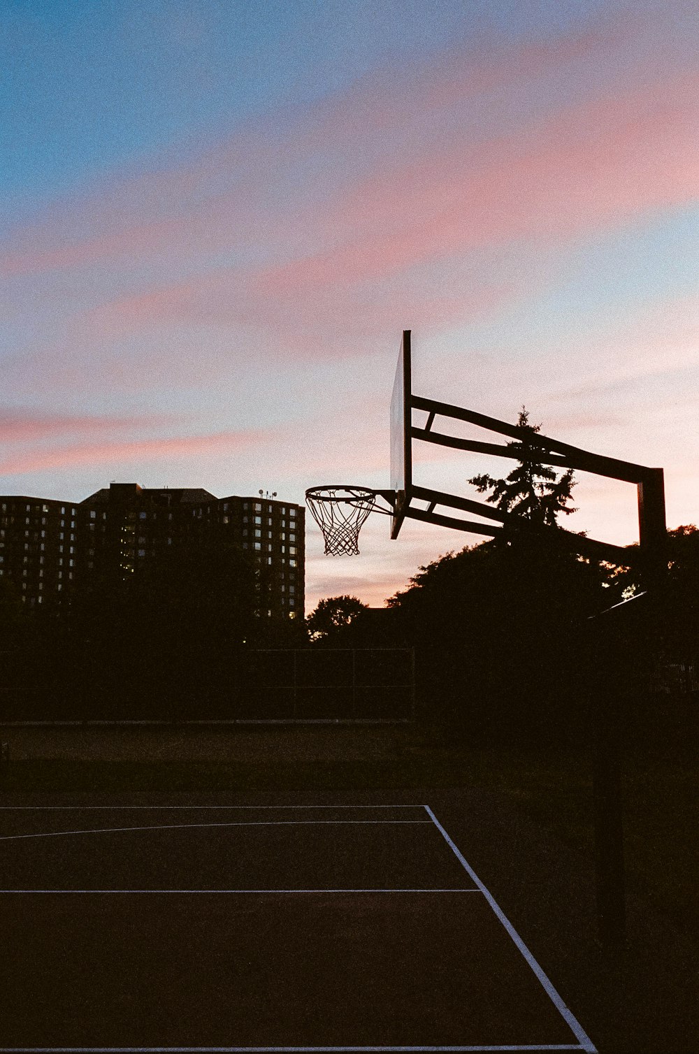 silhouette of basketball hoop during sunset