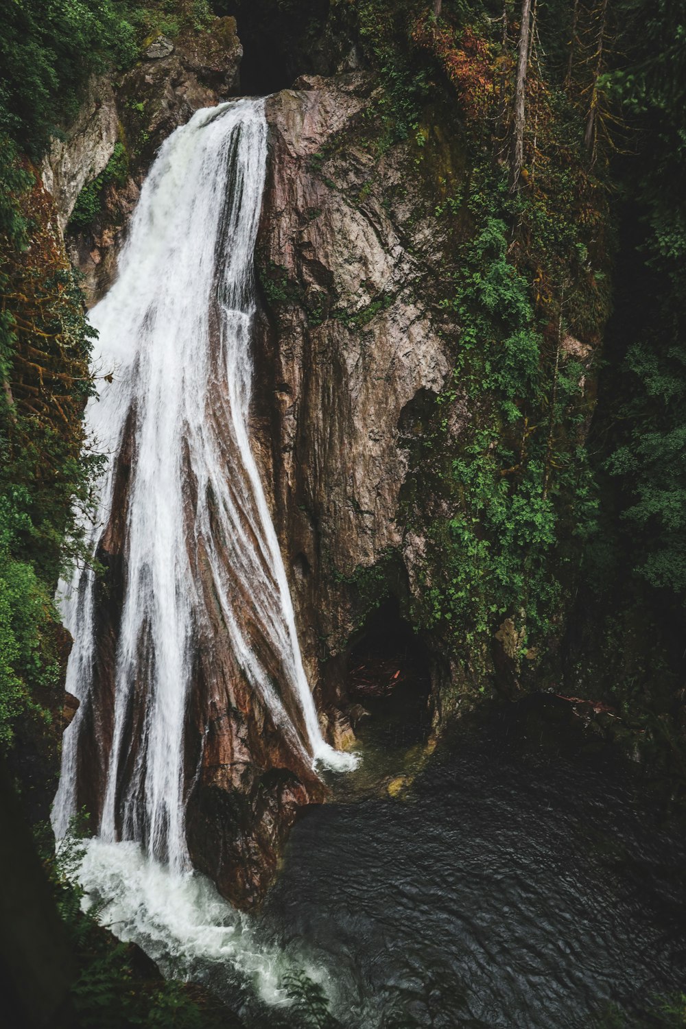 water falls on brown rocky mountain